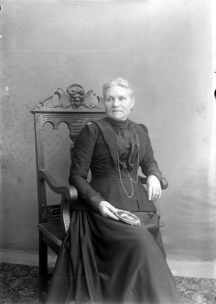 Dame en noir tenant un portrait de jeune fille